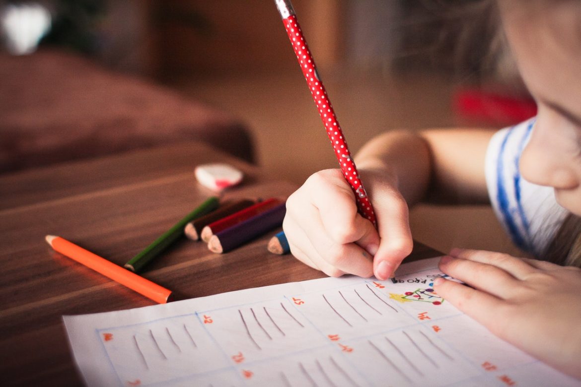 bambina che scrive con la matita